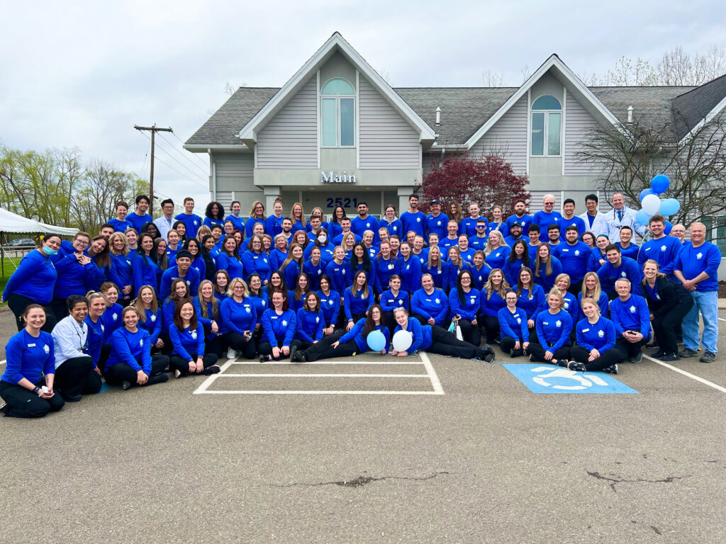 Group staff photo in front of Vestal office holding balloons